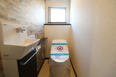 トイレ タンクレス調シャワートイレ。
タオル掛けや収納、カウンターが一体になったコンパクトな手洗器が付いています。
